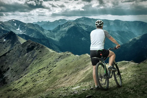 Man with bicycle around mountains — Stock Photo, Image