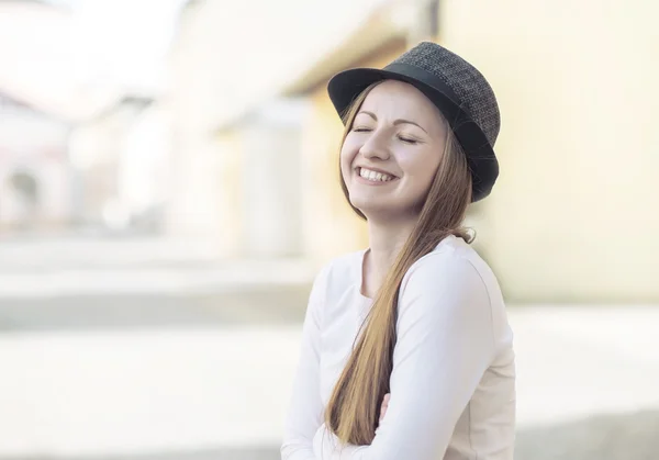 Улыбающаяся женщина в шляпе на улице — стоковое фото