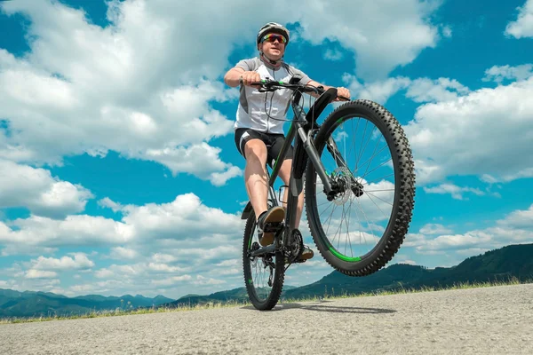 Hombre con bicicleta aroun montañas — Foto de Stock