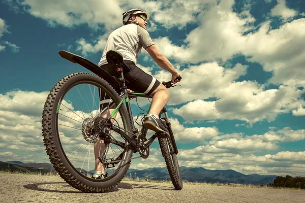Homem com bicicleta ao redor das montanhas — Fotografia de Stock