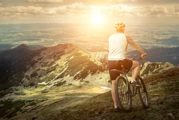 Uomo con bicicletta aroun montagne — Foto Stock