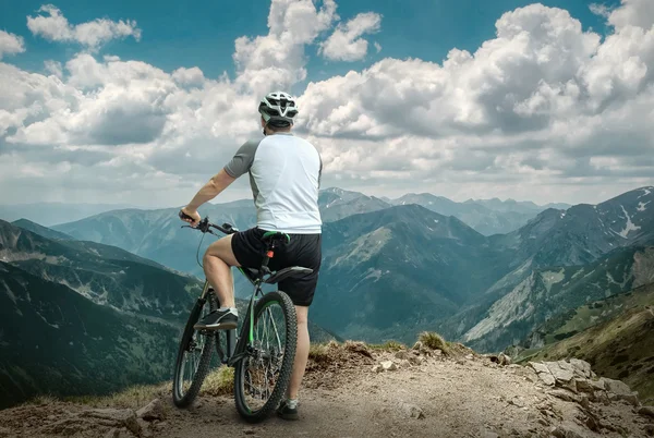 Чоловік з велосипедом збуджує гори — стокове фото