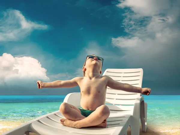 Enfant en lunettes de soleil amusant près de l'eau — Photo