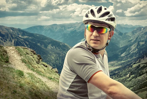 Hombre con bicicleta aroun montañas — Foto de Stock