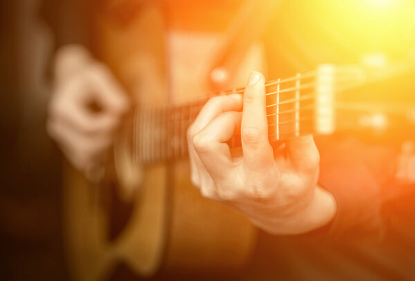 человек играет на акустической гитаре
