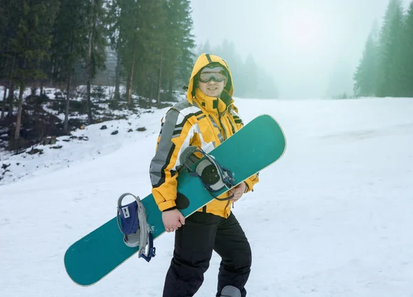 Man in goggles stay with snowboard — Stock Photo, Image