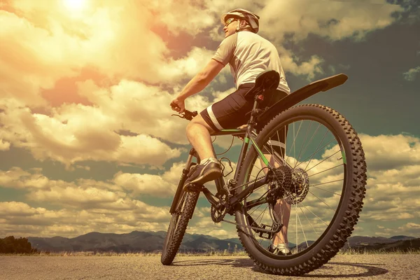 Uomo con bicicletta aroun montagne — Foto Stock