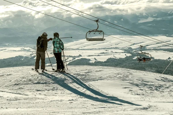 Пара лыжников смотрит на зимние горы — стоковое фото