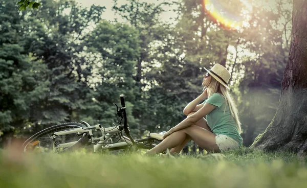그녀의 자전거 근처에 앉아 여자 — 스톡 사진