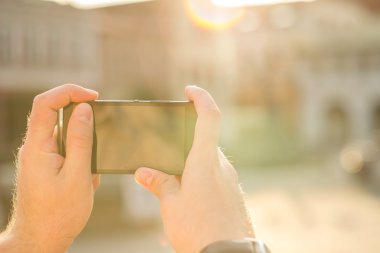 Telefon güneş ışığı altında olan adam