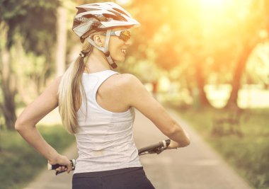 kadın parkta bisikletle.