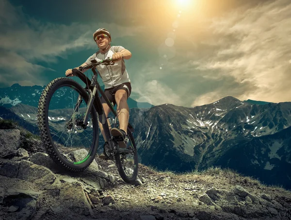 Homem com bicicleta aroun montanhas — Fotografia de Stock