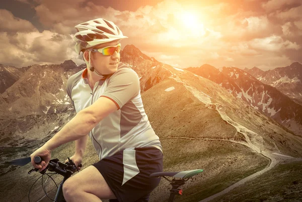 Hombre con bicicleta aroun montañas — Foto de Stock