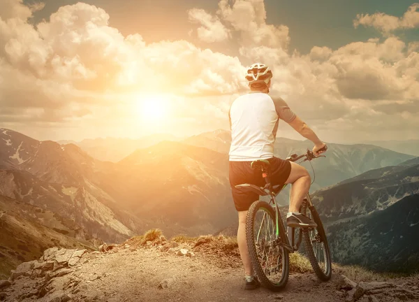 Man with bicycle aroun mountains — Stock Photo, Image