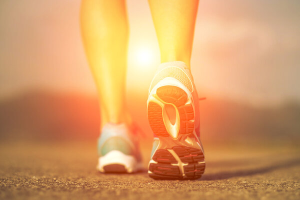 Runner athlete feet running on road