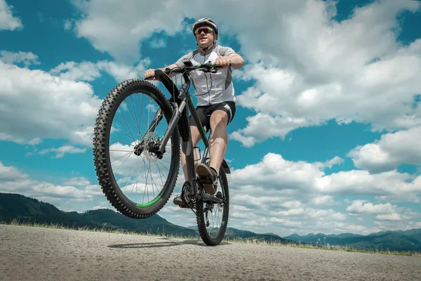 Человек с велосипедом в горах — стоковое фото