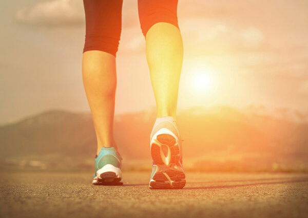 Runner athlete feet running on road