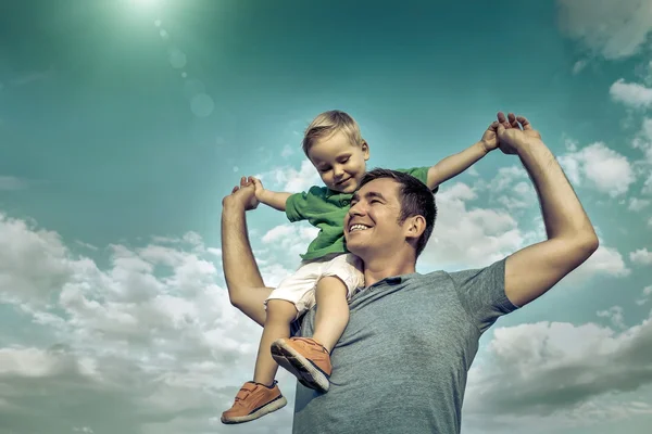 Figlio seduto su padre — Foto Stock