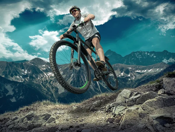 Hombre con bicicleta aroun montañas — Foto de Stock