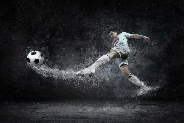 Splash of drops around football player — Stock Photo, Image