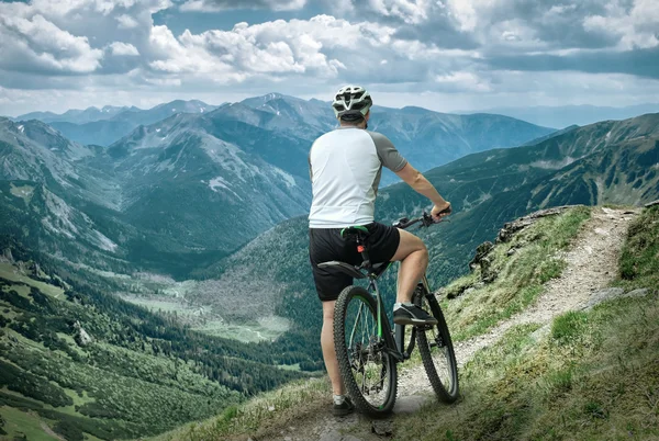 Mann mit Fahrrad in den Bergen — Stockfoto