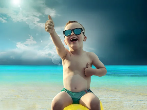 Enfant en lunettes de soleil amusant près de l'eau — Photo