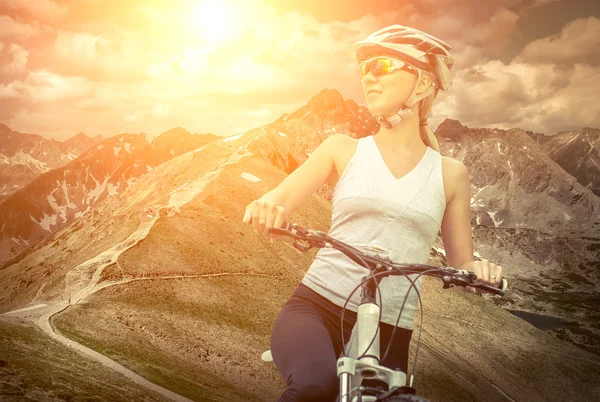 Vrouw in helm op de fiets Rechtenvrije Stockafbeeldingen