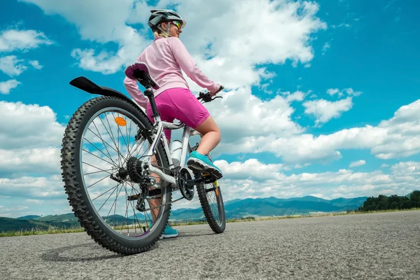 美丽的女人，骑在自行车上 免版税图库照片