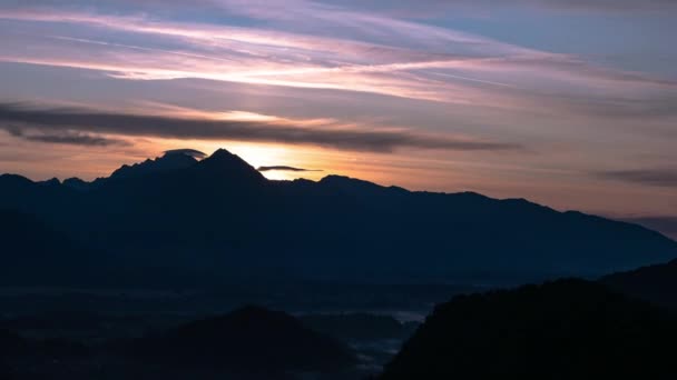 Time-lapse vista sobre o belo nascer do sol sobre as majestosas colinas com o Lago Bled na Eslovénia em uma manhã nebulosa frio. — Vídeo de Stock