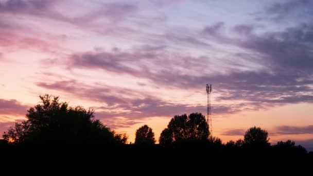 Vista de lapso de tiempo sobre una hermosa puesta de sol detrás de una torre de antena de radio. — Vídeo de stock