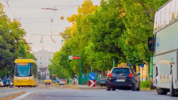 SZEGED, HUNGRIA - JULHO 11, 2019: Vista de lapso de tempo na rotunda com carros e bondes passando na rua Boldogasszony boulevard em Szeged, Hungria. — Vídeo de Stock