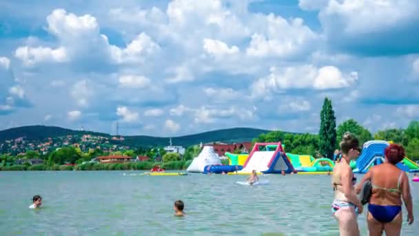 VELENCE, HUNGARY - AUGUST 06, 2019: Time-lapse вид на людей, які плавають і грають в озері Веленс в Веленсі, Угорщина в сонячний літній день.. — стокове відео