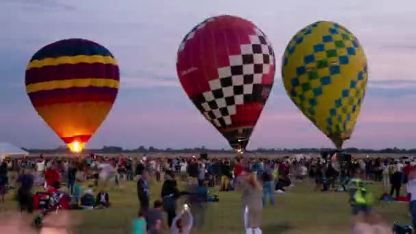 SZEGED, HUNGRIA - SETEMBRO 14, 2019: Vista em time-lapse sobre os balões de ar quente antes da decolagem no aeroporto de Szeged com a multidão dos participantes do evento Szeged International Airshow. — Vídeo de Stock