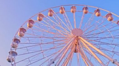 Güneşli bir sonbahar gününde hareket eden dönme dolabın yakın görüntüsü.