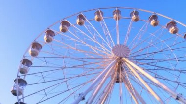 Güneşli bir sonbahar gününde hareket eden dönme dolabın yakın görüntüsü.