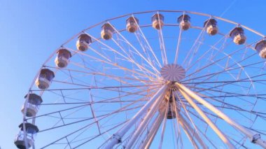 Güneşli bir sonbahar gününde hareket eden dönme dolabın yakın görüntüsü.