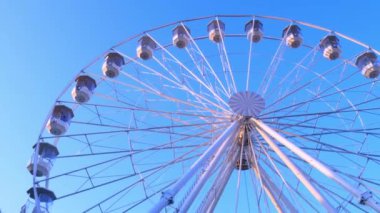 Güneşli bir sonbahar gününde hareket eden dönme dolabın yakın görüntüsü.