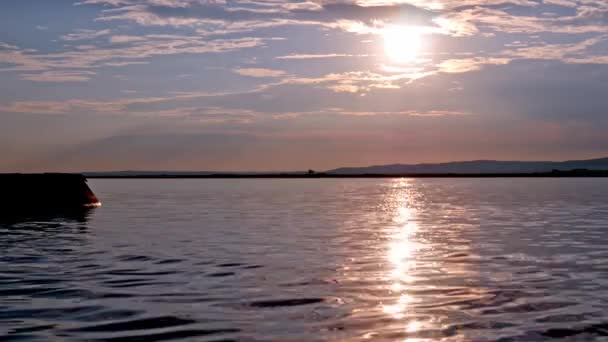 Вид на закат над озером Веленце с солнцем на поверхности воды в Венгрии. — стоковое видео
