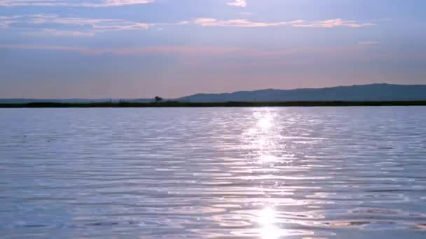 Вигляд на захід сонця над озером Веленті з сонцем, що відбивається на поверхні води в Угорщині.. — стокове відео