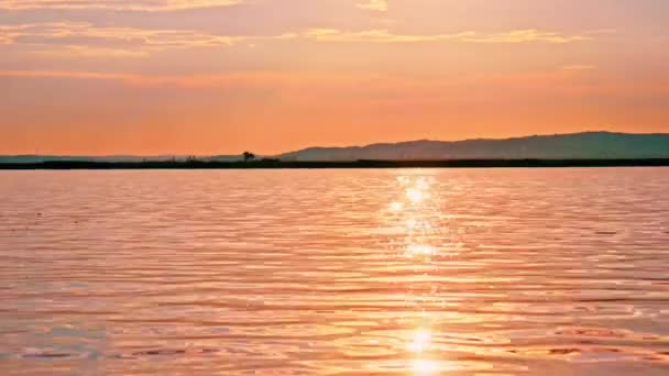 Вид на закат над озером Веленце с солнцем на поверхности воды в Венгрии. — стоковое видео