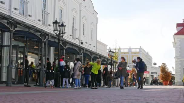 PARNDORF, OOSTENRIJK - 06 mei 2021: Mensen wachten in de rij in Designer Outlet Parndorf om in de winkels te komen tijdens de coronavirus covid 19 pandemie in Parndorf, Oostenrijk. — Stockvideo