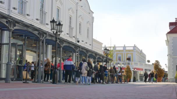 PARNDORF, ÁUSTRIA - MAIO 06, 2021: As pessoas estão esperando na fila no Designer Outlet Parndorf para entrar nas lojas durante a pandemia do coronavírus covid 19 em Parndorf, Áustria. — Vídeo de Stock