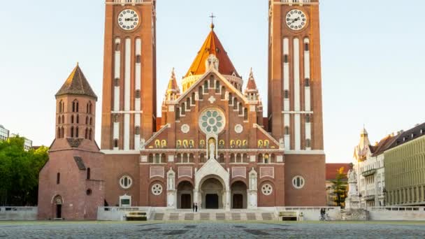 SZEGED, HUNGRIA - 18 de maio de 2021: Vista de lapso de tempo sobre a Igreja Votice e as pessoas na praça em Szeged, Hungria à noite. — Vídeo de Stock