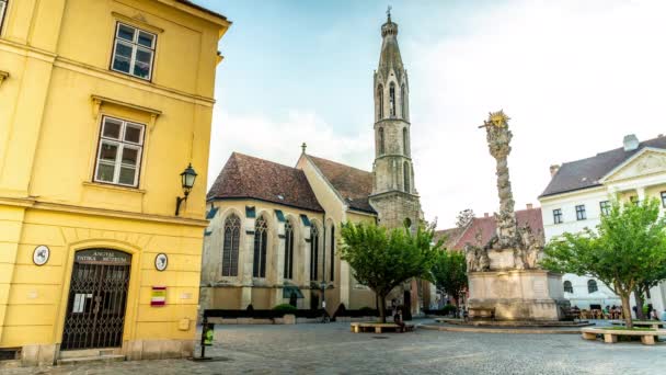 SOPRON, HUNGARY - 13 AĞUSTOS 2021: Kutsanmış Mary Benedictine Kilisesi veya Soproni Nagyboldogasszony fırtınası ve güneşli bir günde Macaristan 'ın Sopron kentindeki sokaklar. — Stok video