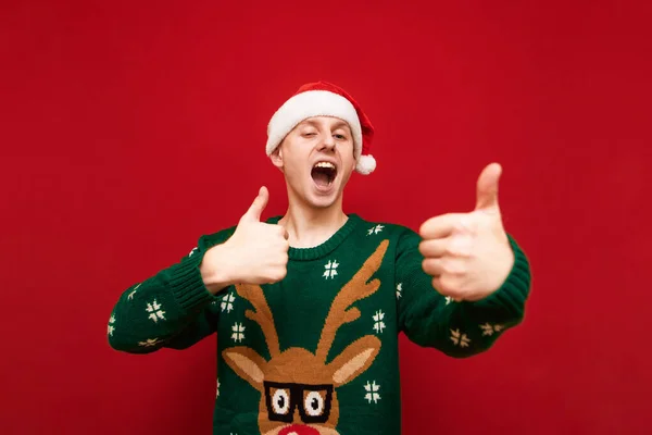 Retrato Tipo Alegre Sombrero Santa Suéter Navidad Con Ciervos Mostrando —  Fotos de Stock