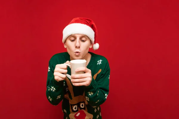 Lustiger Junger Mann Mit Weihnachtsmütze Und Grünem Pullover Steht Mit — Stockfoto