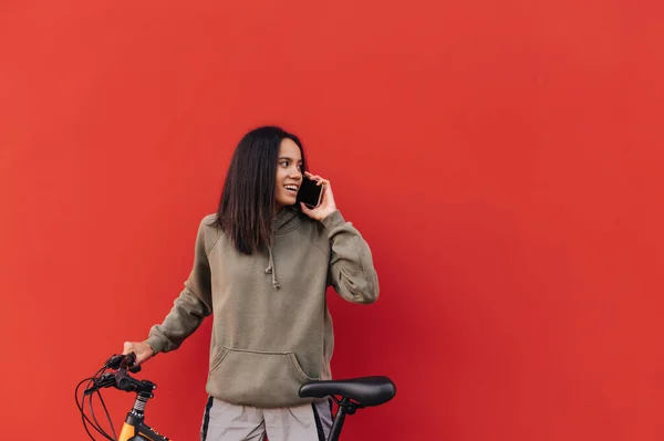 Ευτυχισμένη Γυναίκα Casual Ρούχα Και Ένα Ποδήλατο Επικοινωνεί Στο Τηλέφωνο — Φωτογραφία Αρχείου