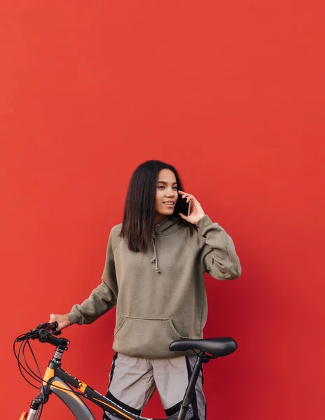 Πορτρέτο Μιας Χαριτωμένης Ισπανίδας Αθλητικά Στέκεται Ένα Ποδήλατο Φόντο Κόκκινου — Φωτογραφία Αρχείου