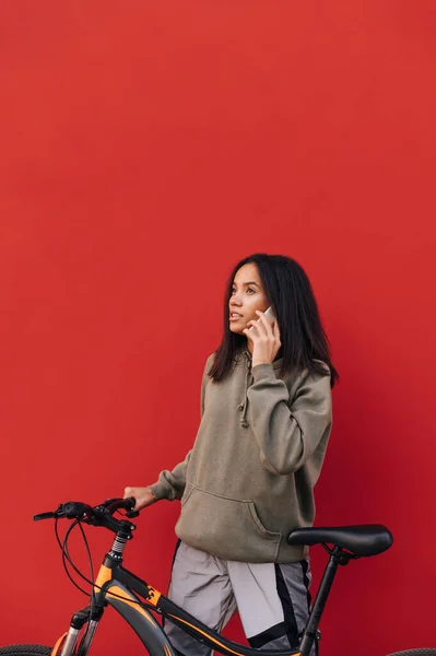 Πορτρέτο Της Ελκυστικής Ισπανικής Γυναίκα Casual Ρούχα Ποδήλατο Απομονώνονται Κόκκινο — Φωτογραφία Αρχείου