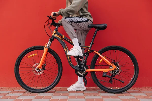 Chiudi Foto Delle Gambe Della Donna Della Bicicletta Sfondo Rosso — Foto Stock
